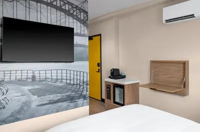 a room with a flat screen tv on a wall at voco Astoria by IHG in New York
