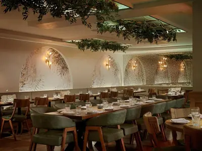 a dining room with a long table and chairs at voco Astoria by IHG in New York