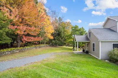 a house with a driveway leading to a yard at Vermont Retreat with private pool and tennis court in Wilmington