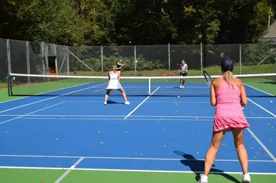 a group of people playing tennis on a tennis court at Vermont Retreat with private pool and tennis court in Wilmington