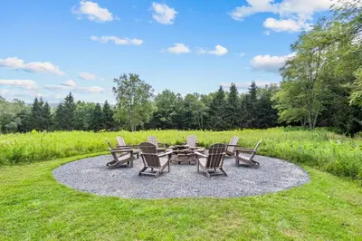 a group of chairs and a table in a field at Vermont Retreat with private pool and tennis court in Wilmington