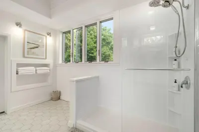 a white bathroom with a shower with a glass door at Vermont Retreat with private pool and tennis court in Wilmington