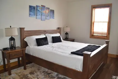 a bedroom with a bed and two tables and a window at Luxury 2 Bedroom Lodge Unit 302 in Wilmington