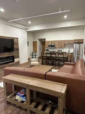 a living room with a large couch and a kitchen at Luxury Townhome 105 in Wilmington