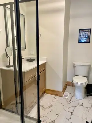 a bathroom with a toilet and a sink and a mirror at Luxury Townhome 105 in Wilmington