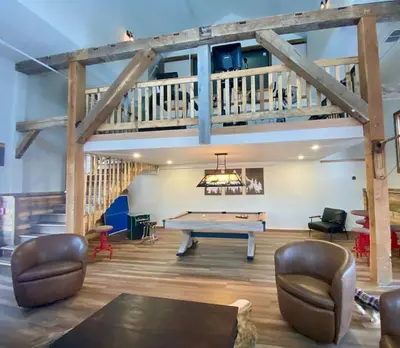 a large room with a pool table and stairs at Luxury TownHome 106 in Wilmington