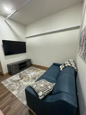 a living room with a blue couch and a flat screen tv at Luxury TownHome 106 in Wilmington