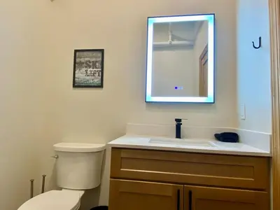 a bathroom with a toilet and a sink and a mirror at Luxury TownHome 106 in Wilmington