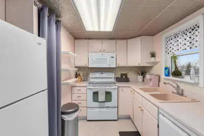 a kitchen with white cabinets and a stove and a sink at Cozy meets fun! in Beacon