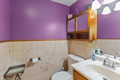 a purple bathroom with a toilet and a sink at Cozy meets fun! in Beacon