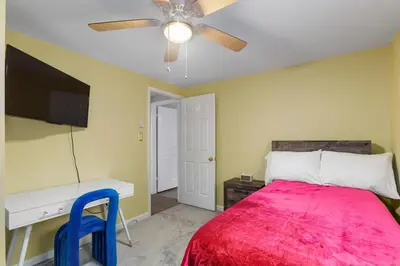 a bedroom with a bed and a desk and a ceiling fan at Cozy meets fun! in Beacon