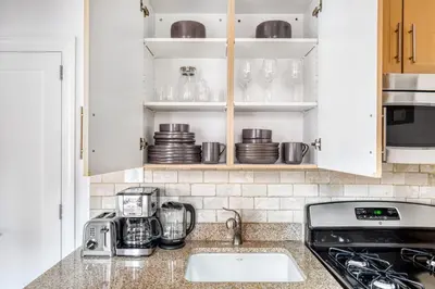 a kitchen with white cabinets and a counter top at Murray Hill Studio w Gym Doorman nr 6 train NYC-628 in New York