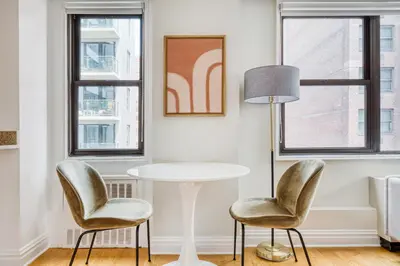 a table and two chairs in a room with windows at Murray Hill Studio w Gym Doorman nr 6 train NYC-628 in New York