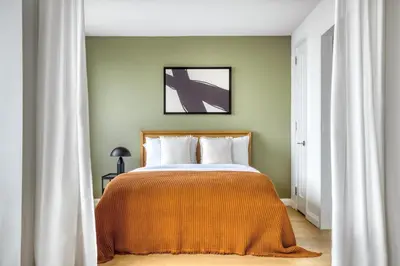 a bedroom with a bed with an orange blanket at Tribeca Studio w City views Gym Pool NYC-110 in New York
