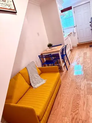 a living room with a yellow couch and a table at le plateau suite in Queens