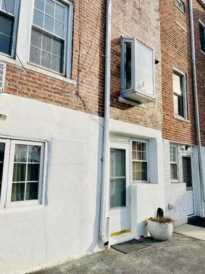 a dog sitting in a pot in front of a building at le plateau suite in Queens