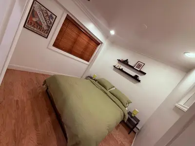 a bedroom with a bed and a window at le plateau suite in Queens