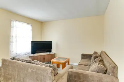 a living room with two couches and a flat screen tv at Near Hospitals Home with Yard in Albany! in Albany