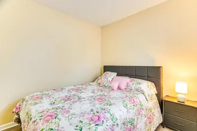 a bedroom with a bed with a floral bedspread at Near Hospitals Home with Yard in Albany! in Albany