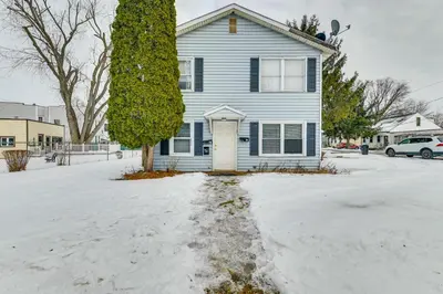 a blue house with a white door in the snow at Near Hospitals Home with Yard in Albany! in Albany