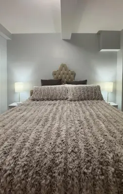 a large bed in a bedroom with two lamps at Fordham University in University Heights