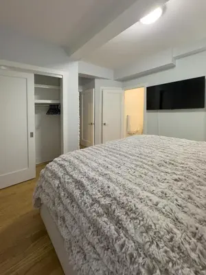a white bedroom with a large bed in it at Fordham University in University Heights