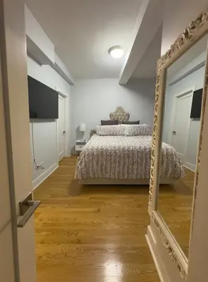 a bedroom with a bed and a mirror at Fordham University in University Heights
