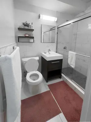 a bathroom with a toilet and a shower and a sink at Fordham University in University Heights