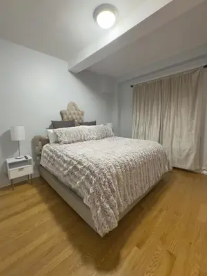 a white bedroom with a bed and a window at Fordham University in University Heights