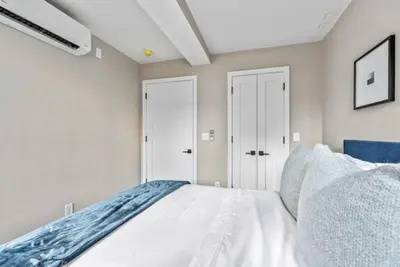 a bedroom with a white bed and white walls at 3BR Penthouse Suite with Massive Private Rooftop in New York