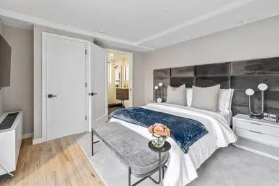 a bedroom with a large bed and a table with flowers on it at 3BR Penthouse Suite with Massive Private Rooftop in New York