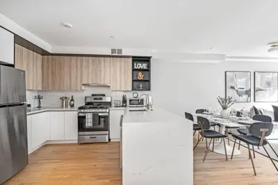 a white kitchen with a table and a dining room at 3BR Penthouse Suite with Massive Private Rooftop in New York
