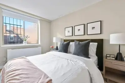 a bedroom with a large white bed and a window at 3BR Penthouse with Massive Private Rooftop in New York
