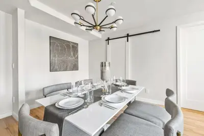 a dining room with a white table and chairs at 3BR Penthouse with Massive Private Rooftop in New York