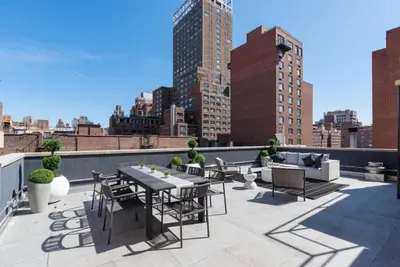 a patio with a table and chairs on a roof at 3BR Penthouse with Massive Private Rooftop in New York
