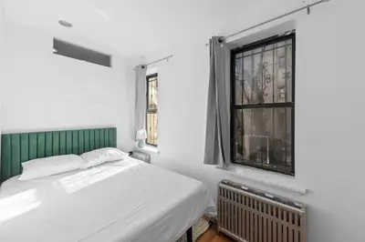 a bedroom with a bed and a window at 105- 4BRs in the Heart of the East Village in New York