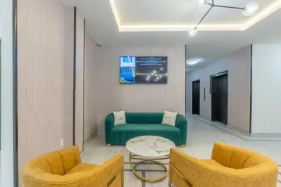 a living room with a green couch and two chairs at Stylish Apt FREE Parking Near NYC & Airport in East Orange