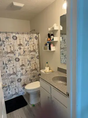 a bathroom with a toilet and a shower curtain at Warmth Private Room in Stillwater Lake Estates