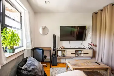 a living room with a tv and a table at BEST LOCATION IN QUEENS, Everything is near by, PRIVATE ROOM, LaGuardia Airport 10min in Queens
