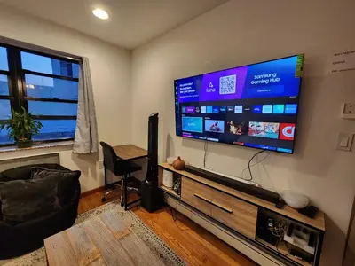 a living room with a large flat screen tv at BEST LOCATION IN QUEENS, Everything is near by, PRIVATE ROOM, LaGuardia Airport 10min in Queens