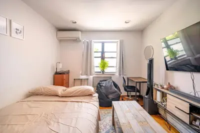 a bedroom with a bed and a desk and a television at BEST LOCATION IN QUEENS, Everything is near by, PRIVATE ROOM, LaGuardia Airport 10min in Queens