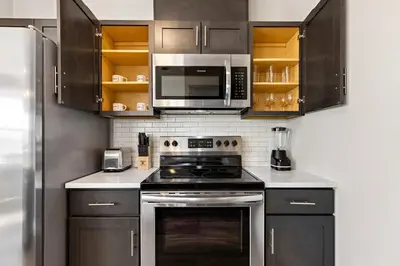 a kitchen with a stove and a microwave at City Views 1BR Free-Parking- Easy NYC Access in Newark