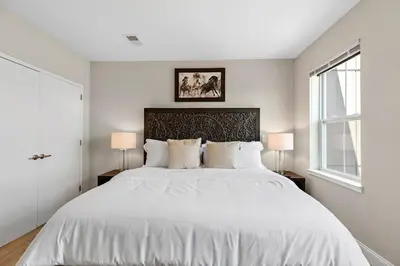 a bedroom with a large white bed with two lamps at City Views 1BR Free-Parking- Easy NYC Access in Newark