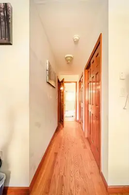 a hallway with wooden floors and white walls at BEST Large Private Room & Private Bathroom, LaGuardia Airport 10min in Queens