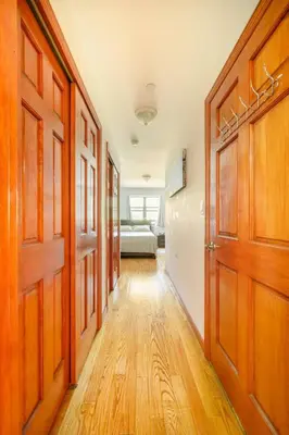 a hallway with wooden doors and a bed in a room at BEST Large Private Room & Private Bathroom, LaGuardia Airport 10min in Queens