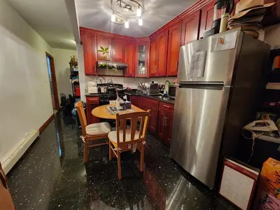 a kitchen with a table and a stainless steel refrigerator at BEST Large Private Room & Private Bathroom, LaGuardia Airport 10min in Queens