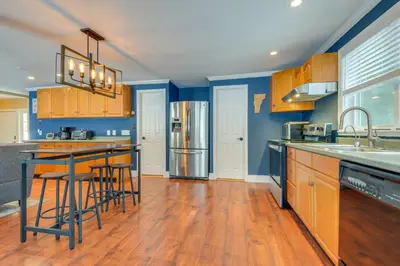 a kitchen with blue walls and wooden cabinets and a counter at Ski, Golf and Hike Spacious Dover Retreat! in Dover