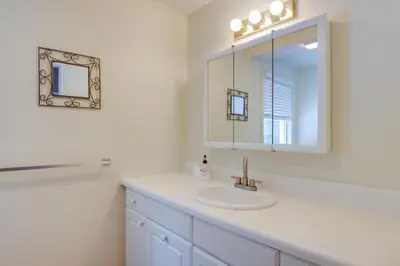 a white bathroom with a sink and a mirror at Ski, Golf and Hike Spacious Dover Retreat! in Dover