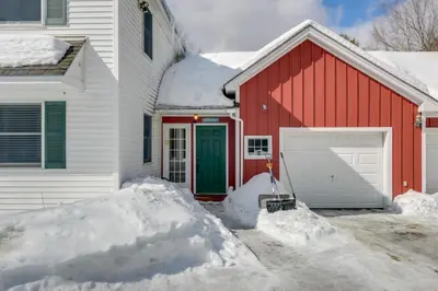 a red and white house with a garage and snow at Ski, Golf and Hike Spacious Dover Retreat! in Dover