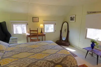 a bedroom with a large bed and a mirror at 1894 Catskills Farmhouse Retreat in Tannersville